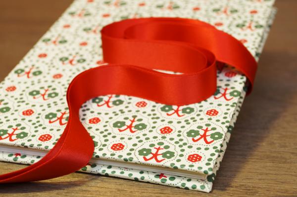 Mini photo album with retro pattern in green and red, red ribbon